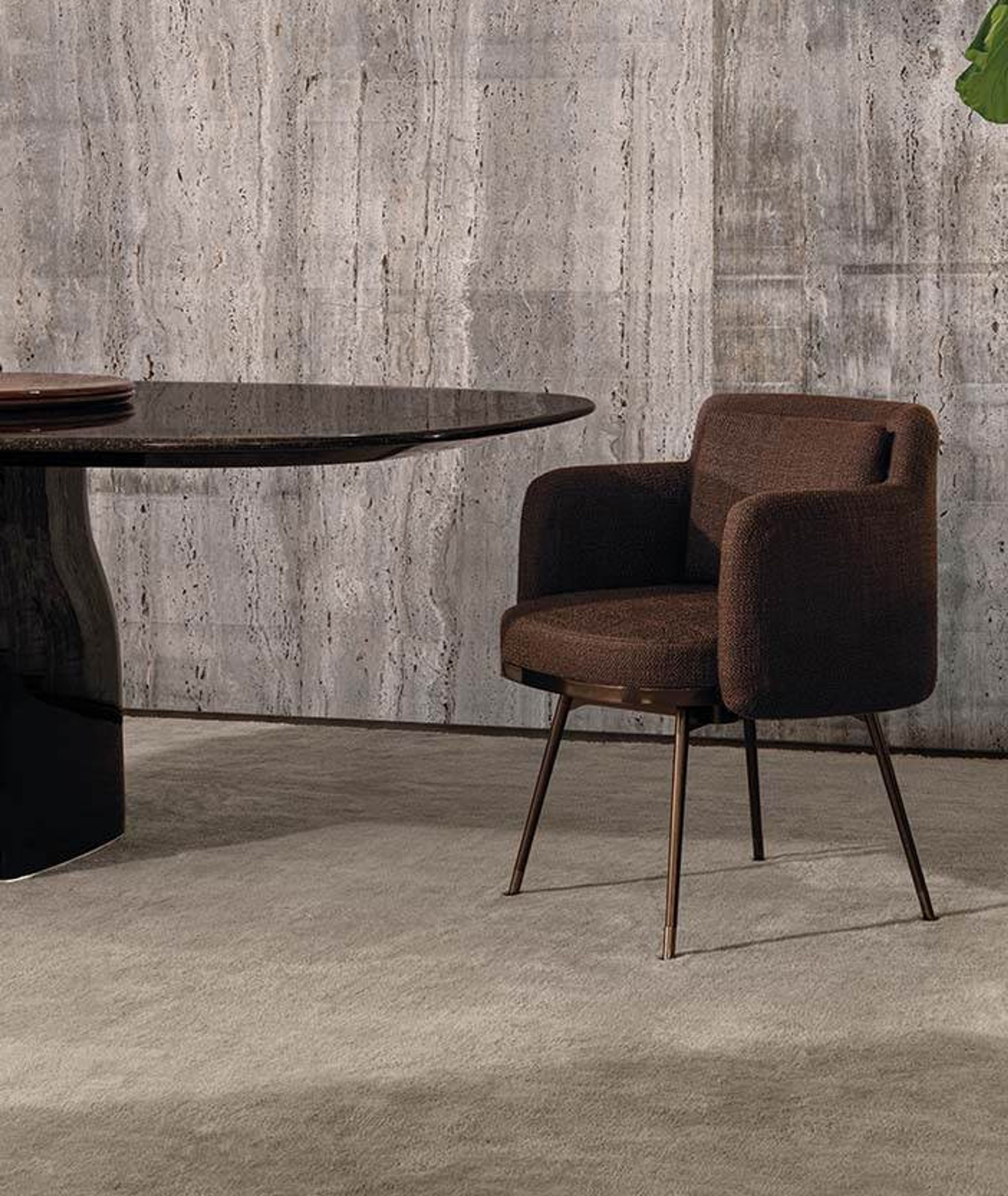 Minotti`s little armchair with an enveloping shell silhouette.