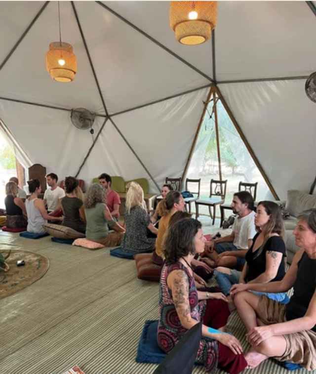 A group sitting together inside a geodesic dome