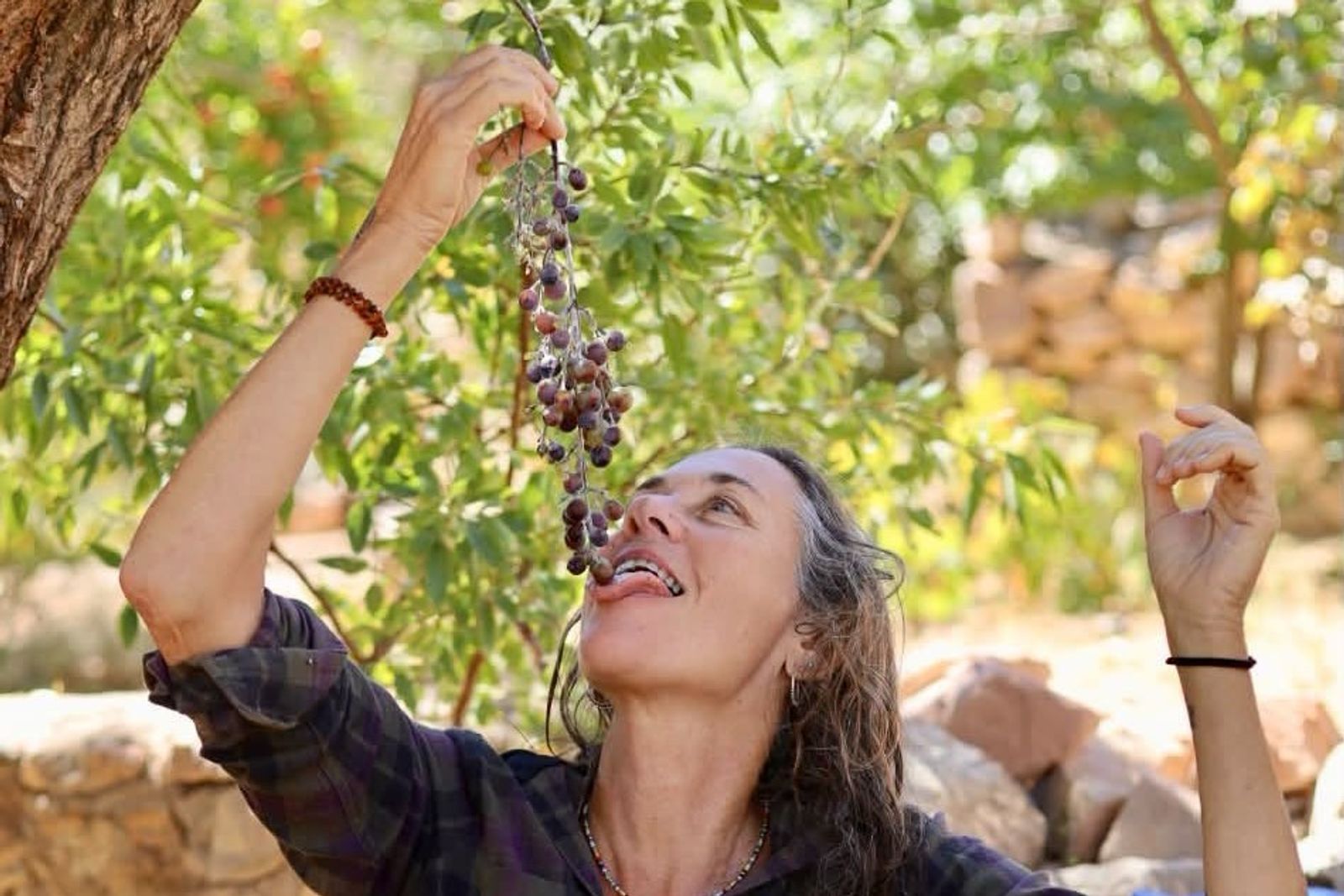 Radhika Sophie practicing Tantra with a bunch of grapes in an orchard in Sinai