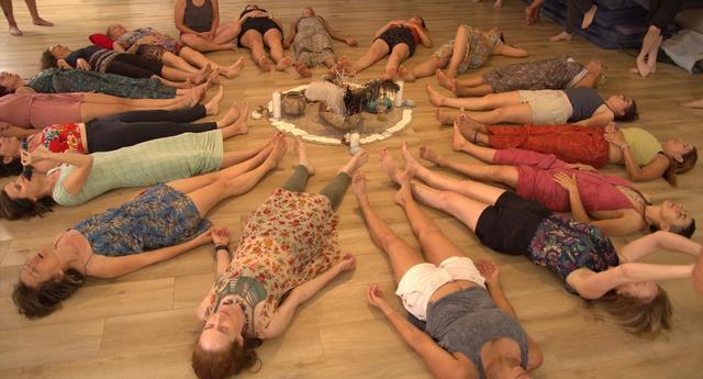 Women lying on the floor in a circle