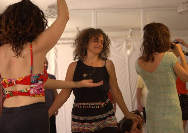 Women dancing together, one with a hand on her heart