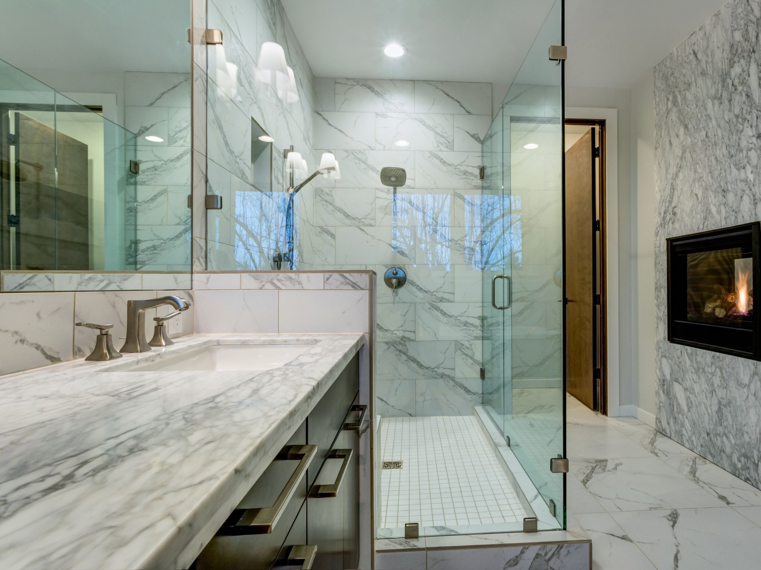 Custom frameless shower door and seamless glass enclosure in a remodeled, spa-like Houston bathroom.
