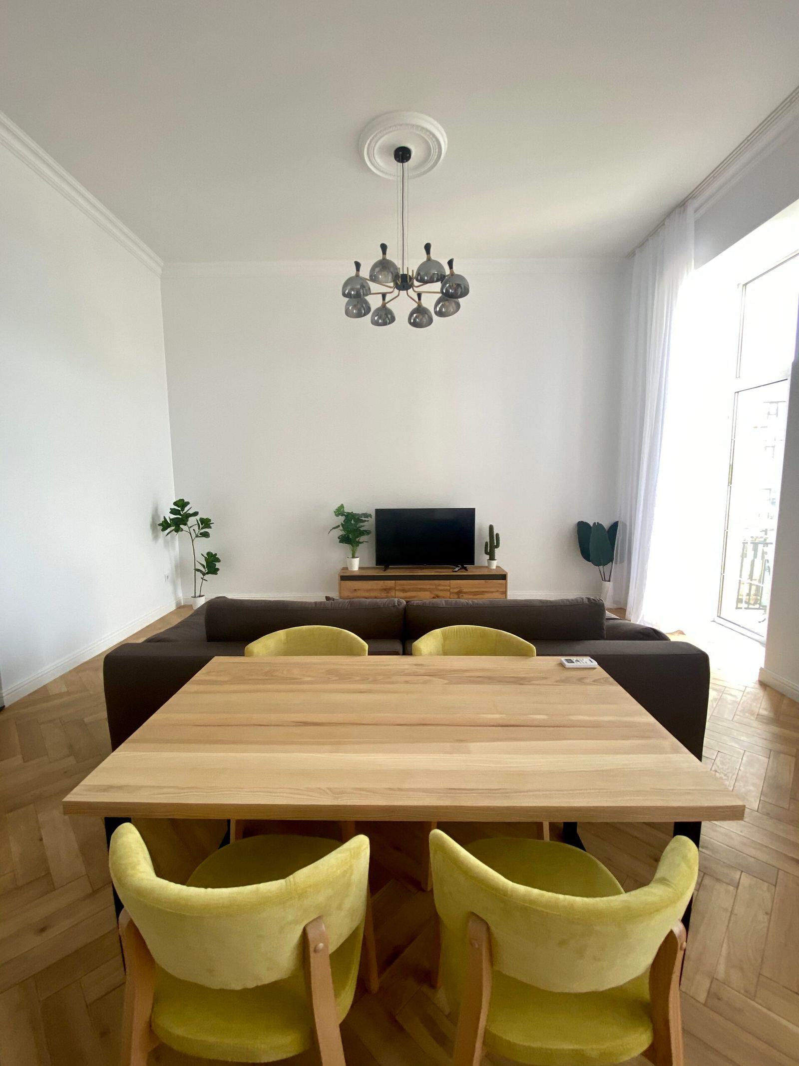 Dining area with wood table, yellow chairs, and modern chandelier, Kruhlouniversytetska 14, Kyiv — Vestor.Estate