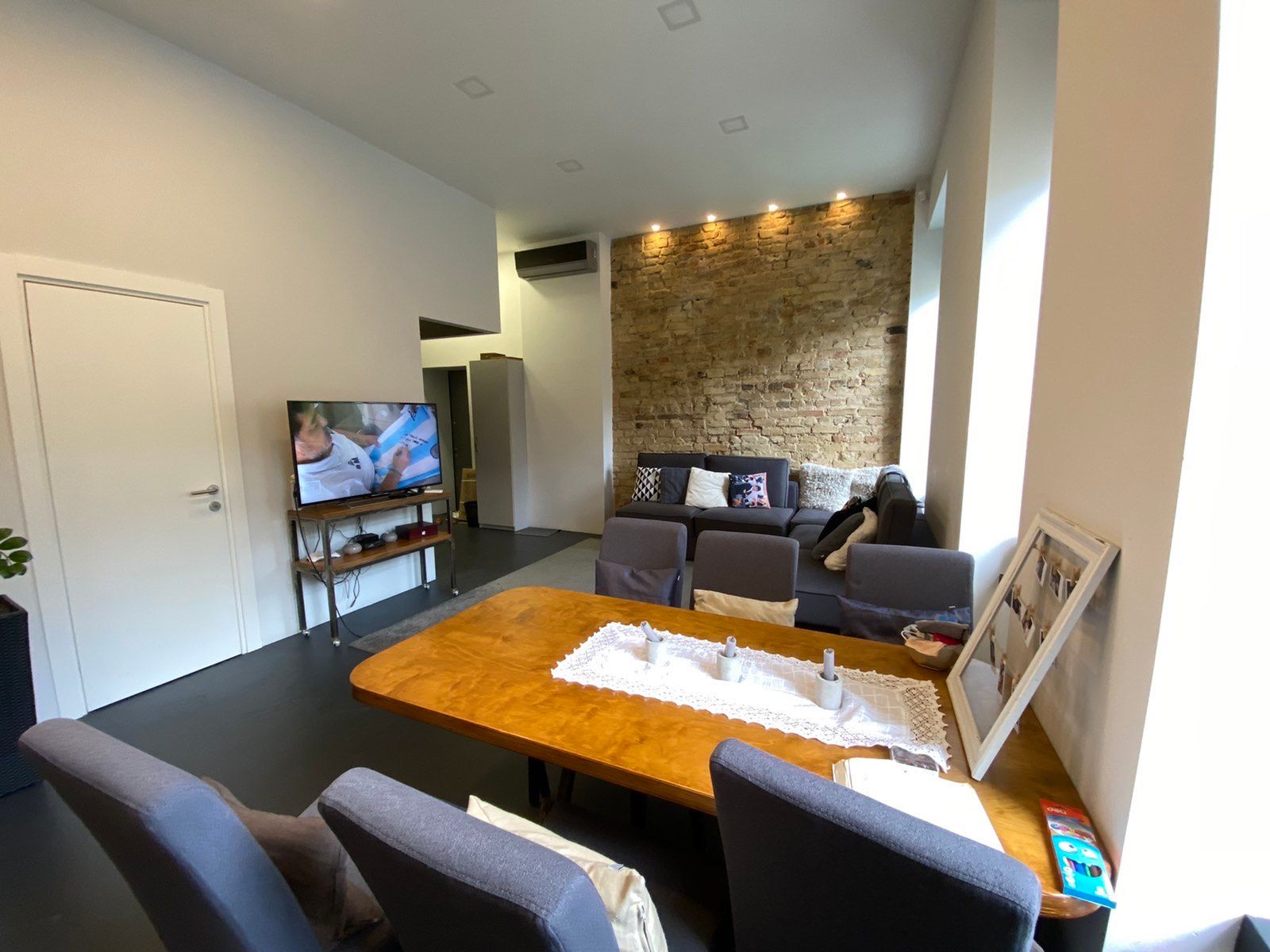 Living room with exposed brick wall, dining table, and sofa, Leontovycha 1, Kyiv — Vestor.Estate
