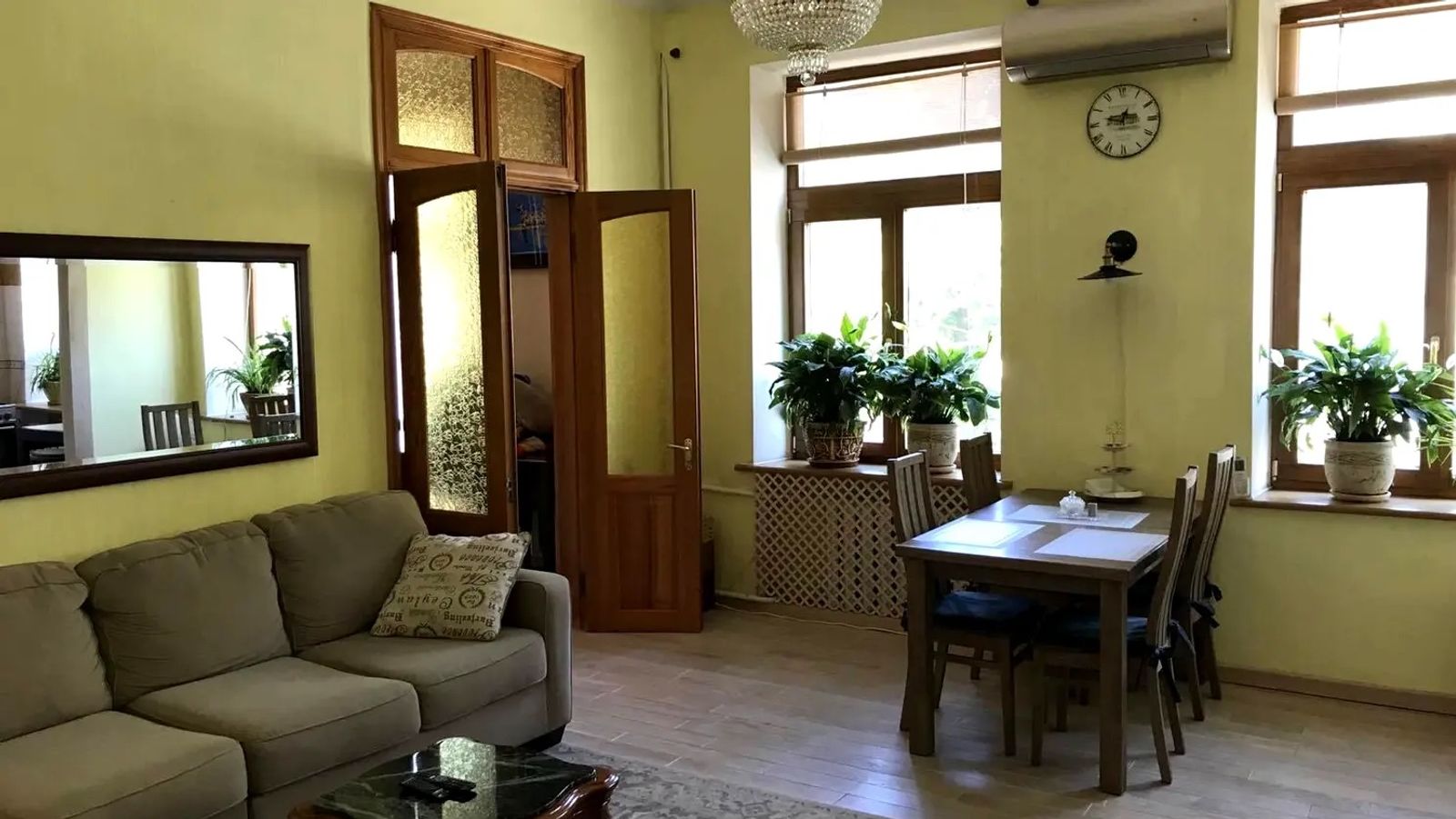 Living room with sofa, dining table, and large windows, Mykhailivska 21A, Kyiv — Vestor.Estate