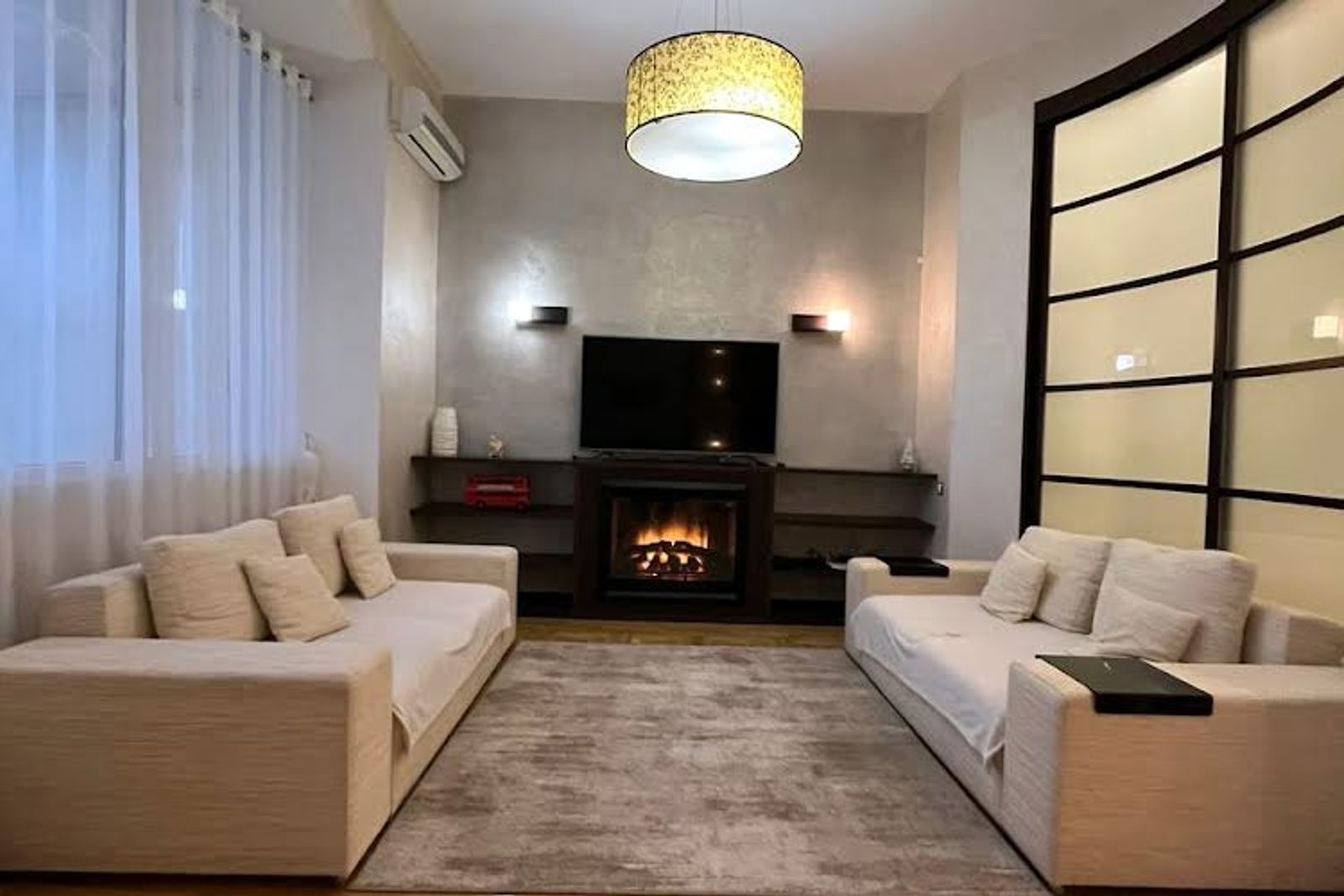 Living room with fireplace, two sofas, and modern sliding doors, Velyka Vasylkivska 25, Kyiv — Vestor.Estate