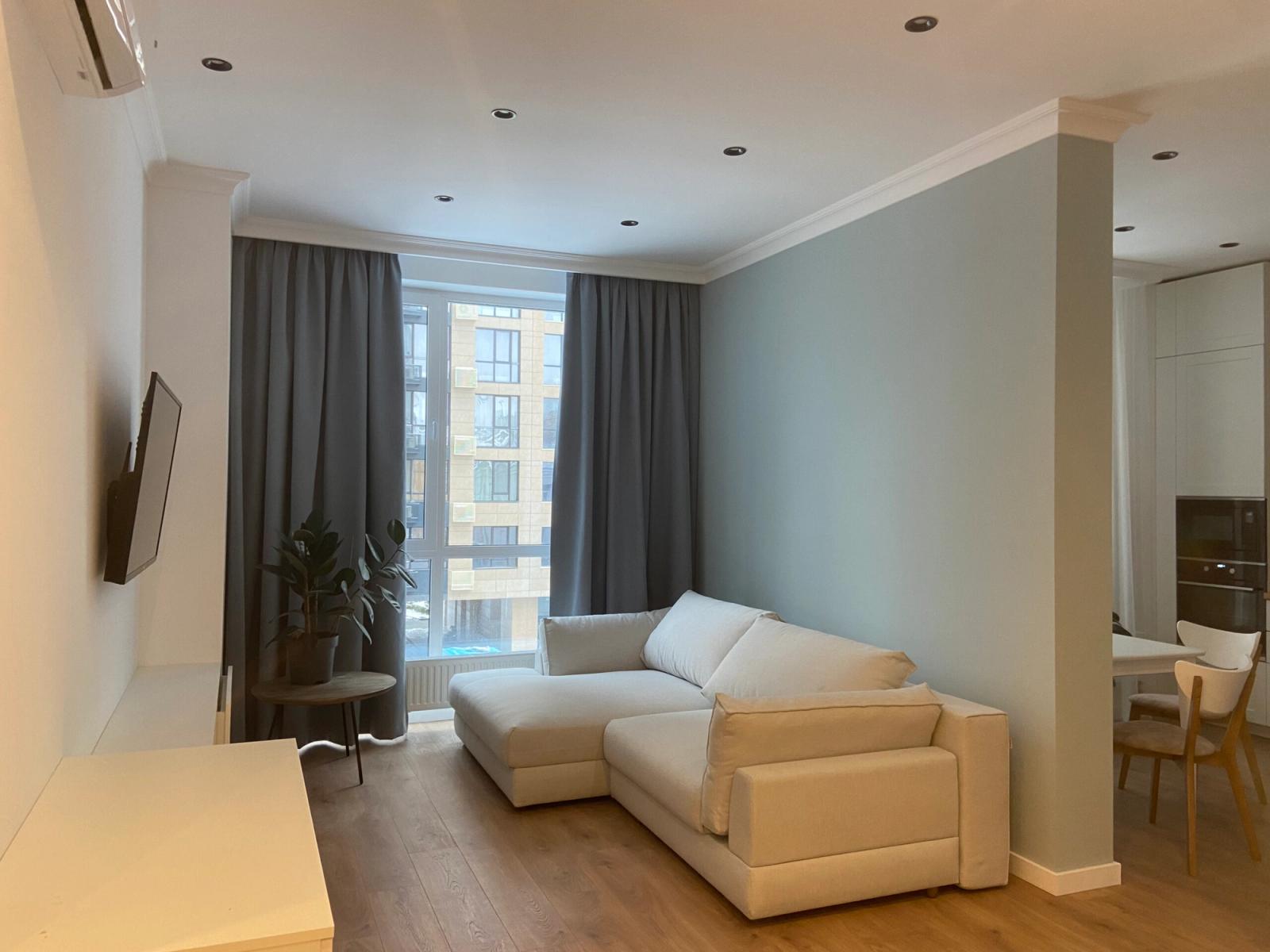 Living room with sectional sofa and large window, Bulvarno-Kudriavska 17b, Kyiv — Vestor.Estate