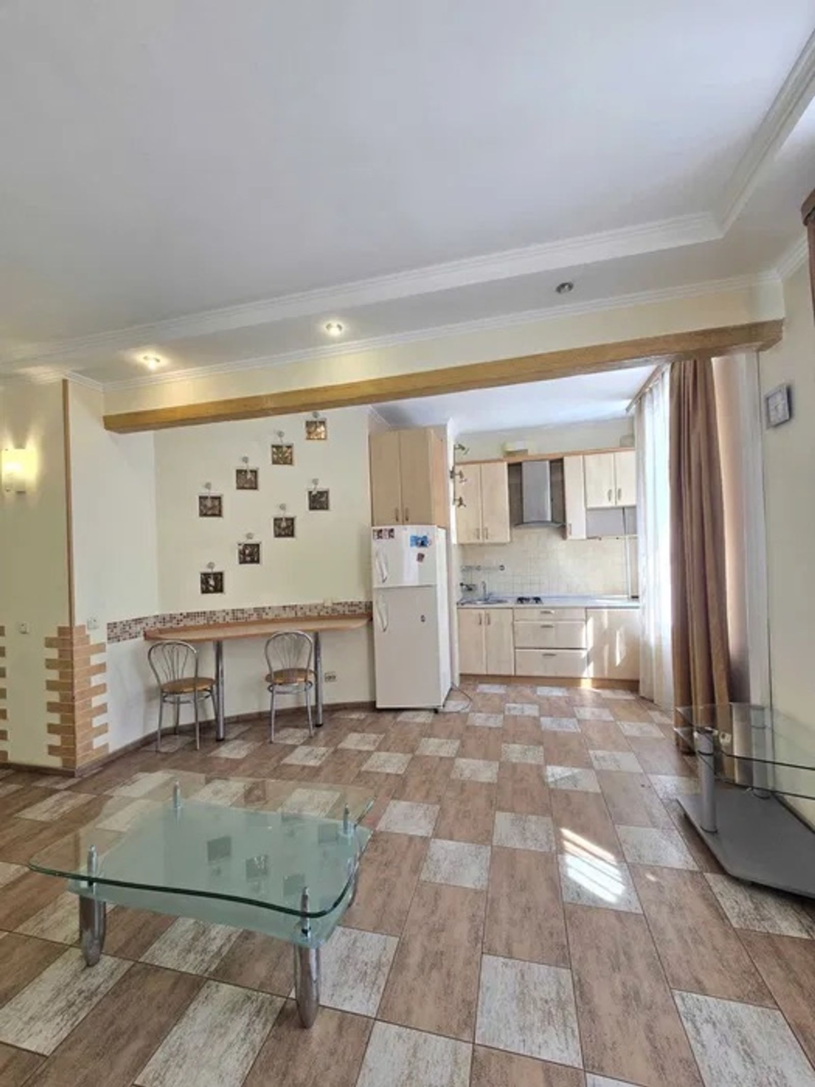 Open-plan living area with kitchen, glass coffee table, and tiled floor, Kyiv — Vestor.Estate