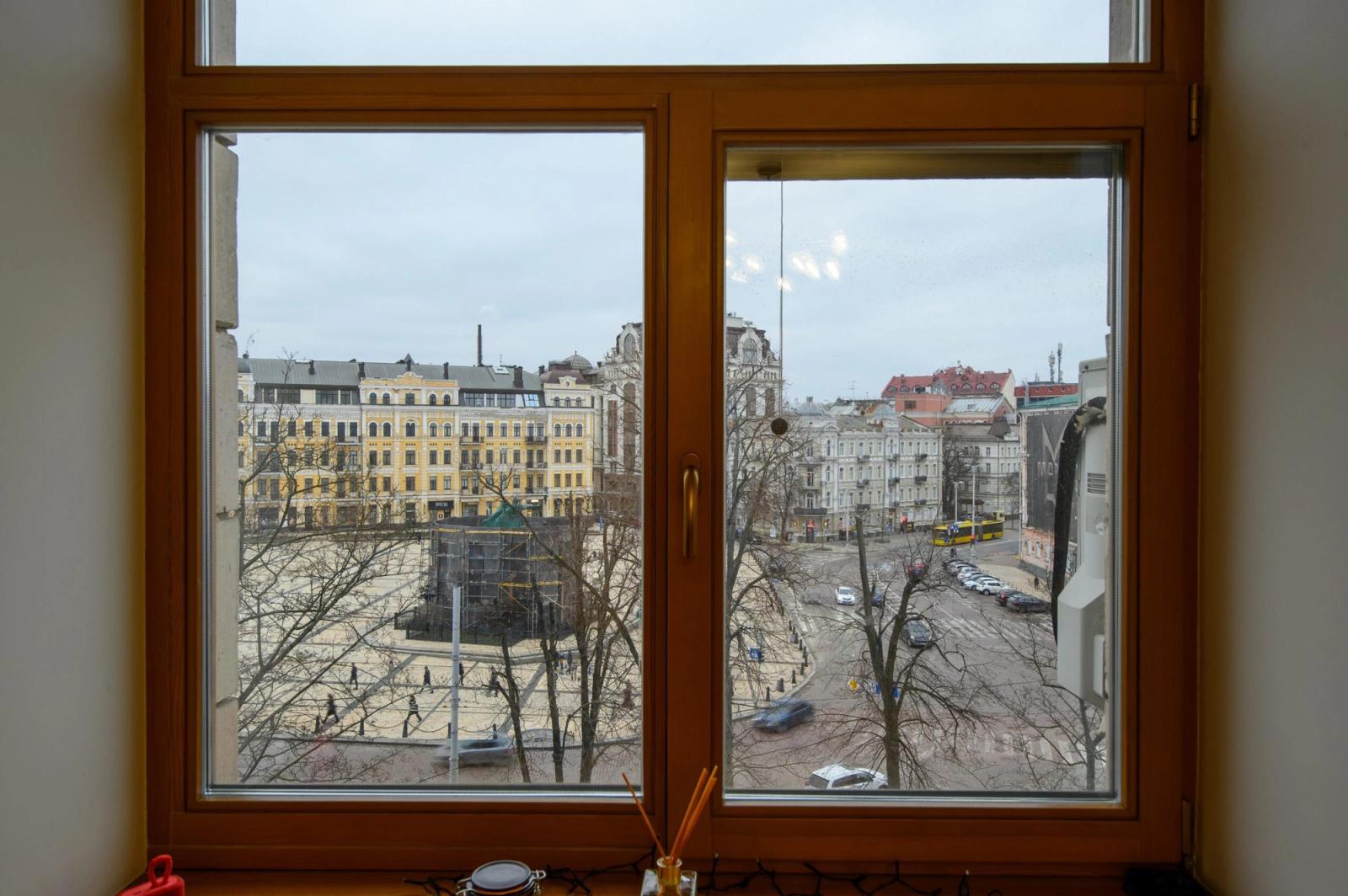 Wooden framed window overlooking city square and buildings, Volodymyrska 19, Kyiv — Vestor.Estate