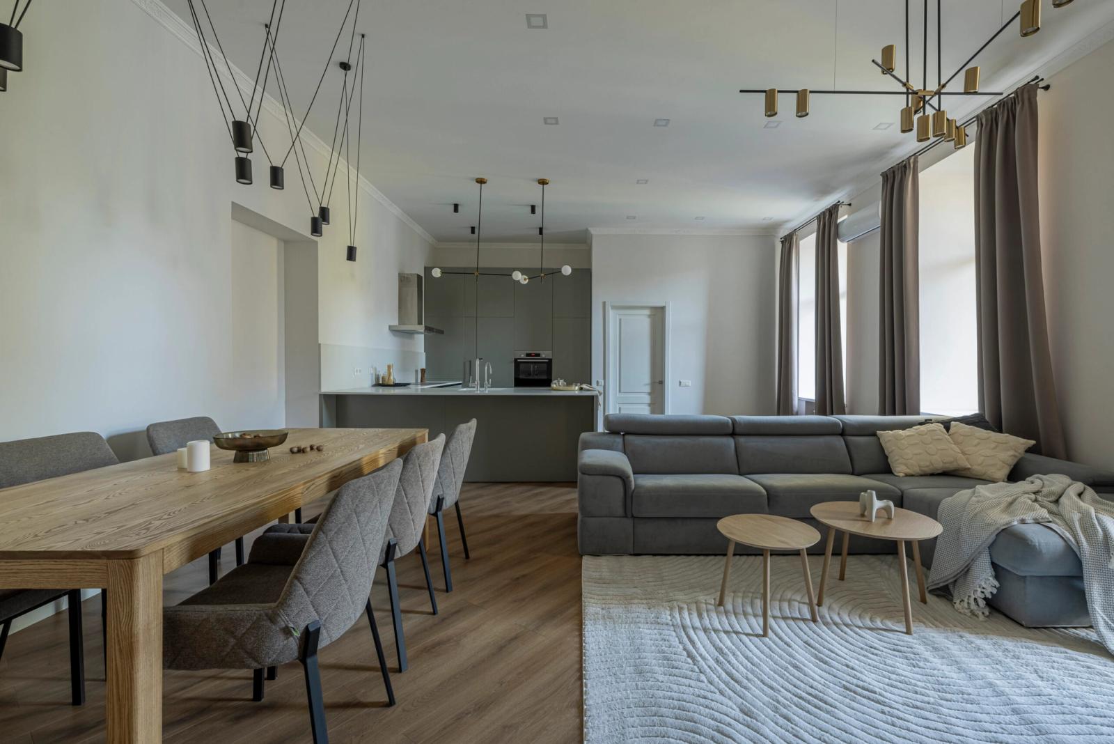 Open-plan living and dining area with modern lighting and sectional sofa, Yaroslaviv Val 14g, Kyiv — Vestor.Estate
