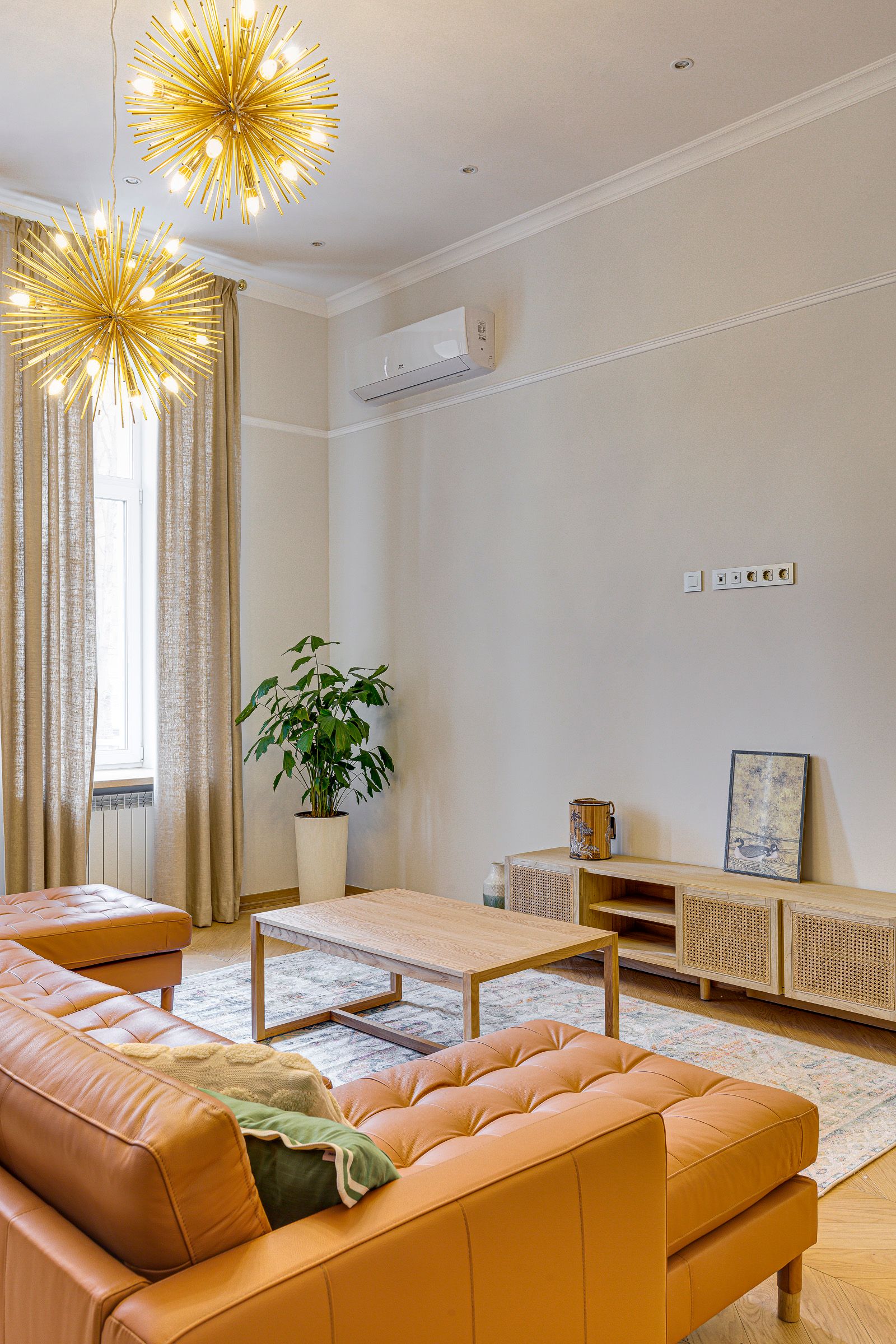 Living room with orange sectional and starburst chandeliers, Velyka Zhytomyrska 8/14, Kyiv — Vestor.Estate