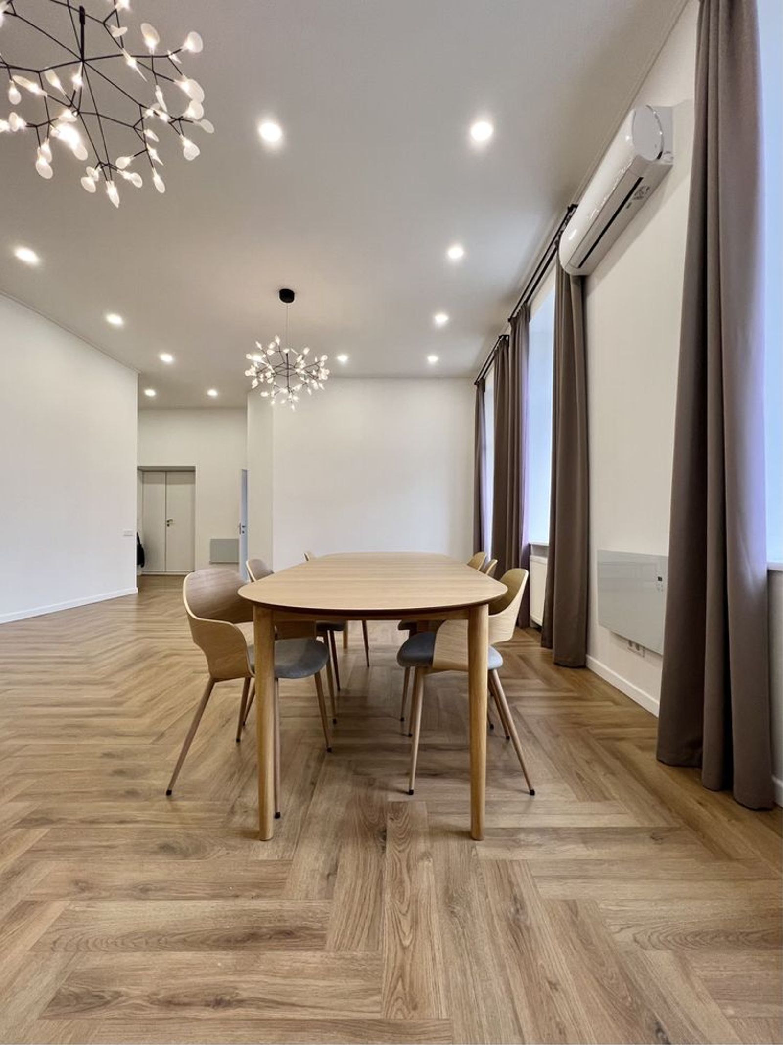 Dining room with light wood floor and modern chandelier, Antonovycha 16, Kyiv — Vestor.Estate