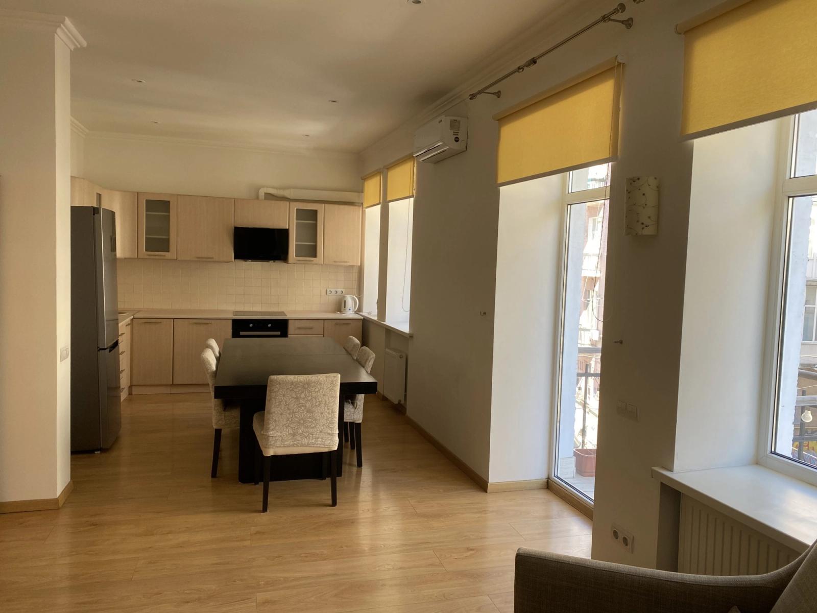Open-plan kitchen with dining area, light wood floors, and ample natural light, Reitarska, Kyiv — Vestor.Estate
