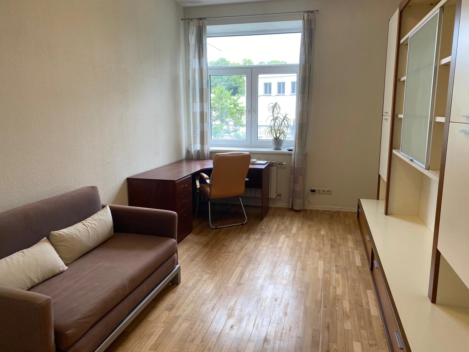 Living area with sofa, desk, and large window, Antonovycha 4, Kyiv — Vestor.Estate