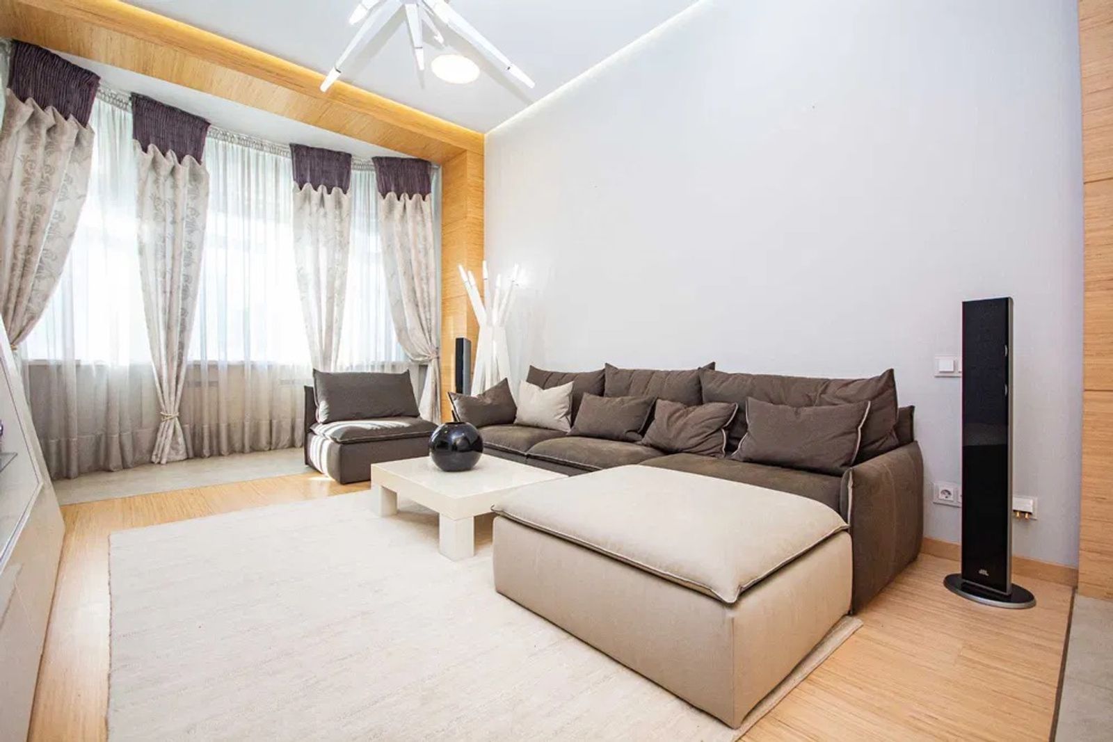 Living room with sectional sofa, ottoman, and large windows, Kruhlouniversytetska 7, Kyiv — Vestor.Estate