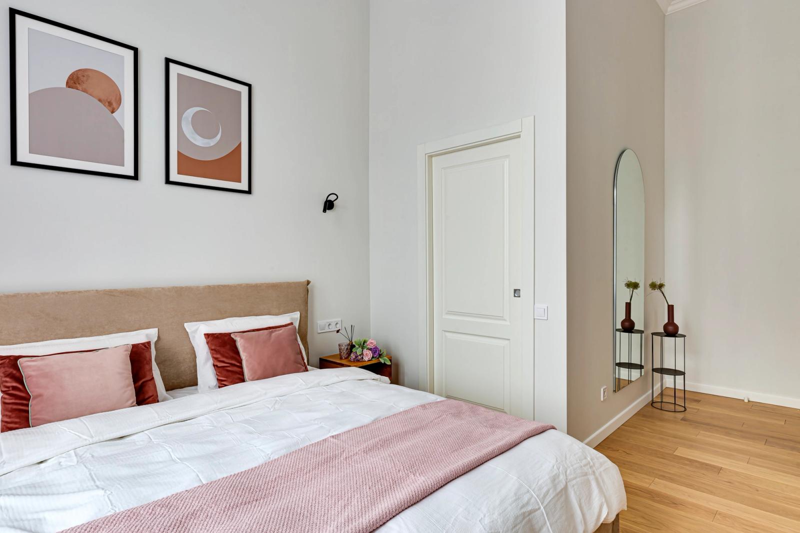 Bedroom with plush pillows, artwork, and arched mirror, Yaroslaviv Val, Kyiv — Vestor.Estate