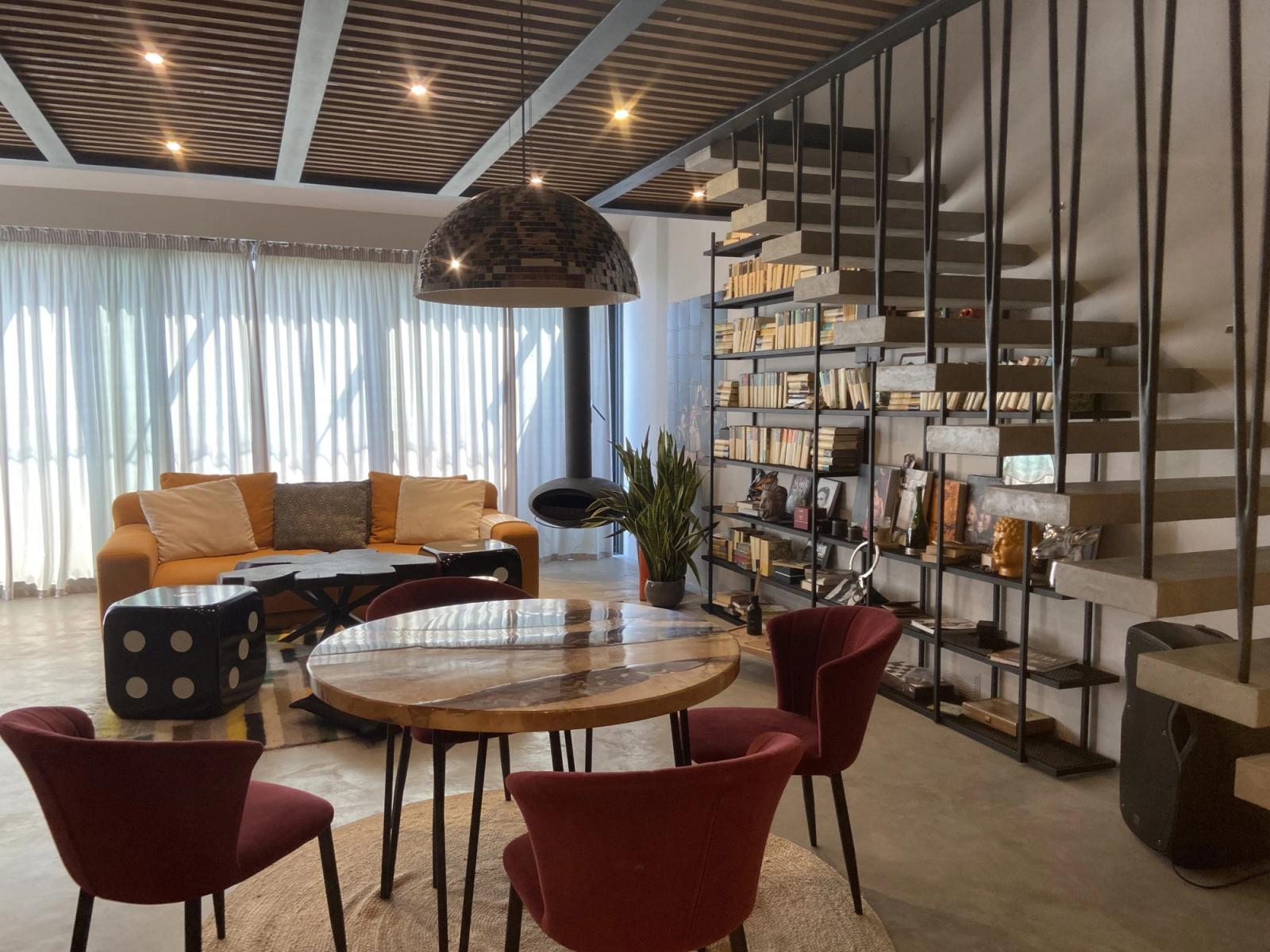 Living room with open staircase, built-in bookshelves, and wood-slatted ceiling, Konstantynivska 34, Kyiv — Vestor.Estate