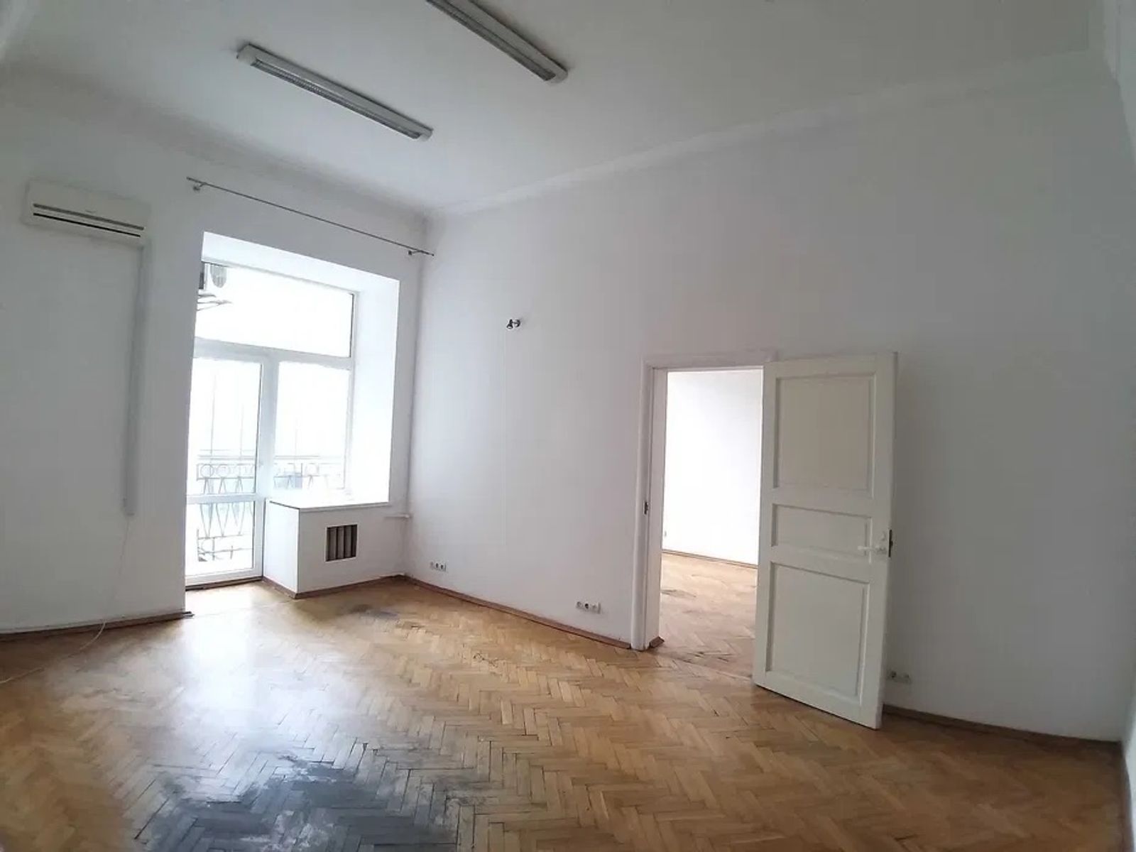 Empty room with large window and parquet flooring, Velyka Vasylkivska 26, Kyiv — Vestor.Estate