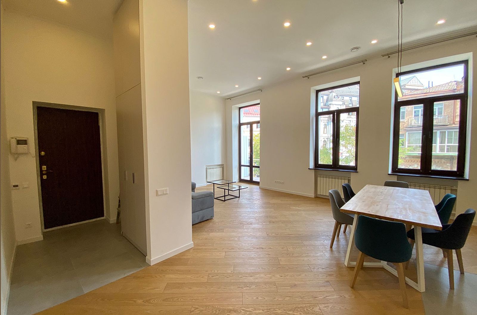 Spacious living and dining area with hardwood floors and large windows, Yaroslaviv Val 13, Kyiv — Vestor.Estate