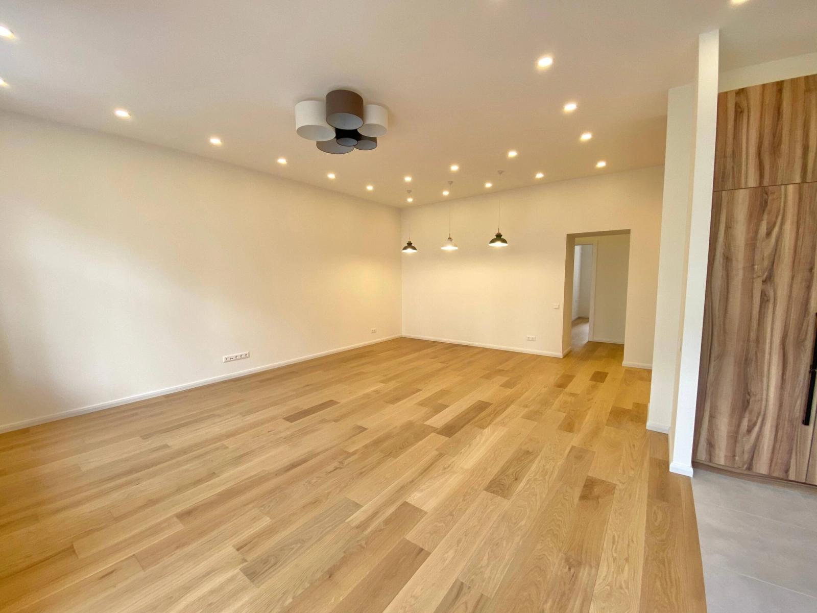 Spacious living area with light wood floors and recessed lighting, Kyiv — Vestor.Estate