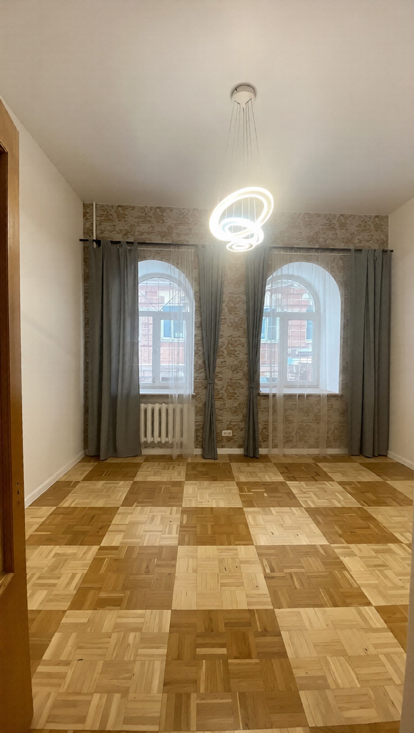 Living room with parquet floor and arched windows, Kyiv — Vestor.Estate