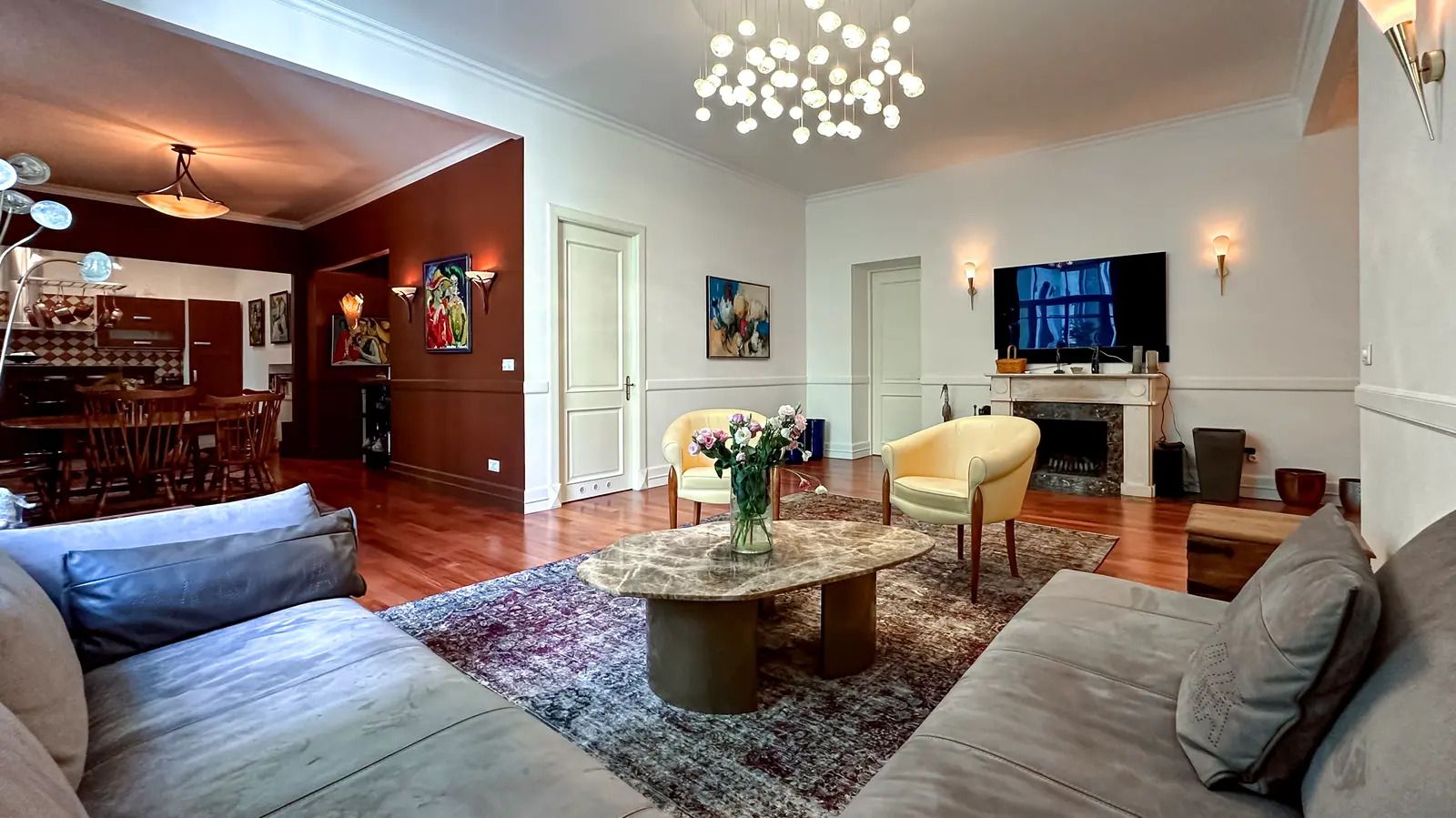 Living room with fireplace, modern chandelier, and open dining area, Tereshchenkivska 13, Kyiv — Vestor.Estate
