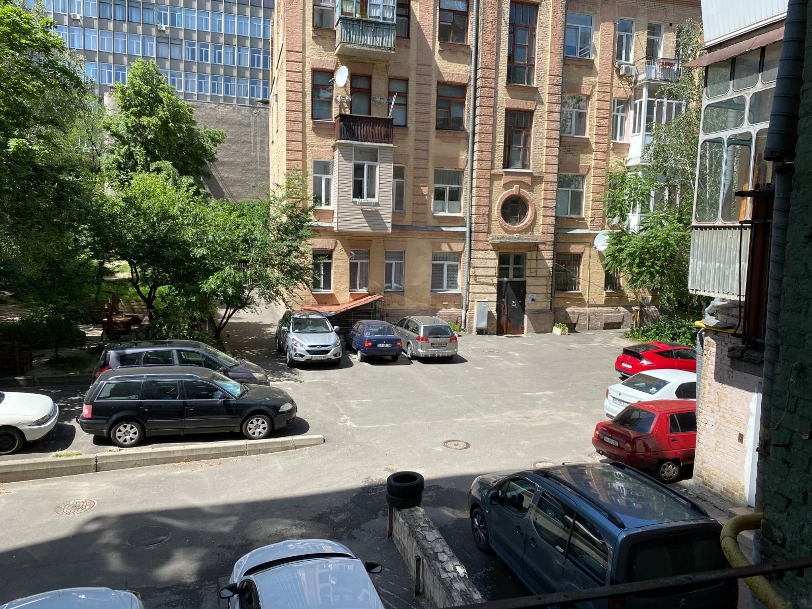 Courtyard parking lot with several cars and brick buildings, Olesia Honchara 88b, Kyiv — Vestor.Estate