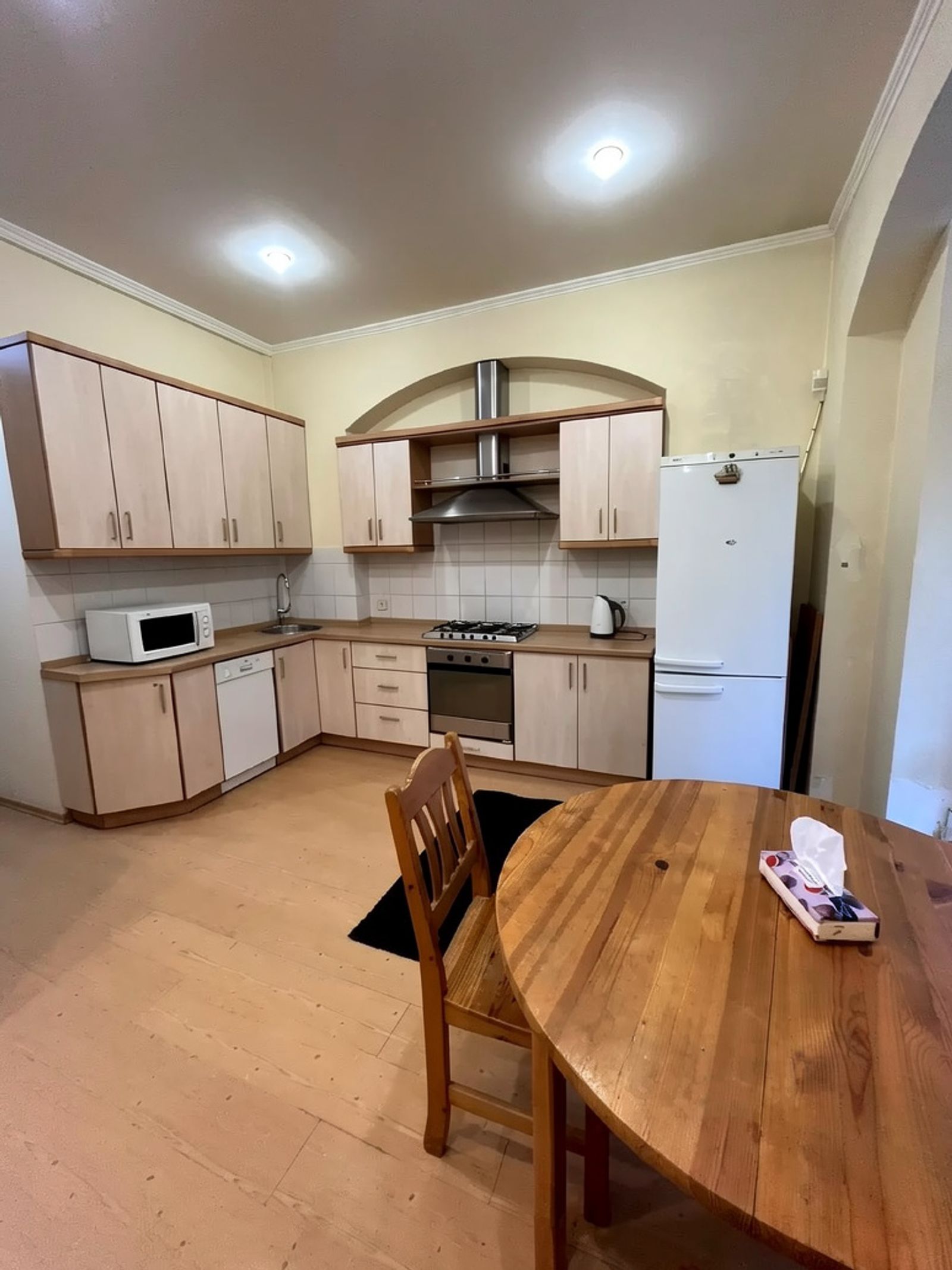 Kitchen with light wood cabinets, stainless steel appliances, and dining table, Yevhena Chykalenka 12, Kyiv — Vestor.Estate