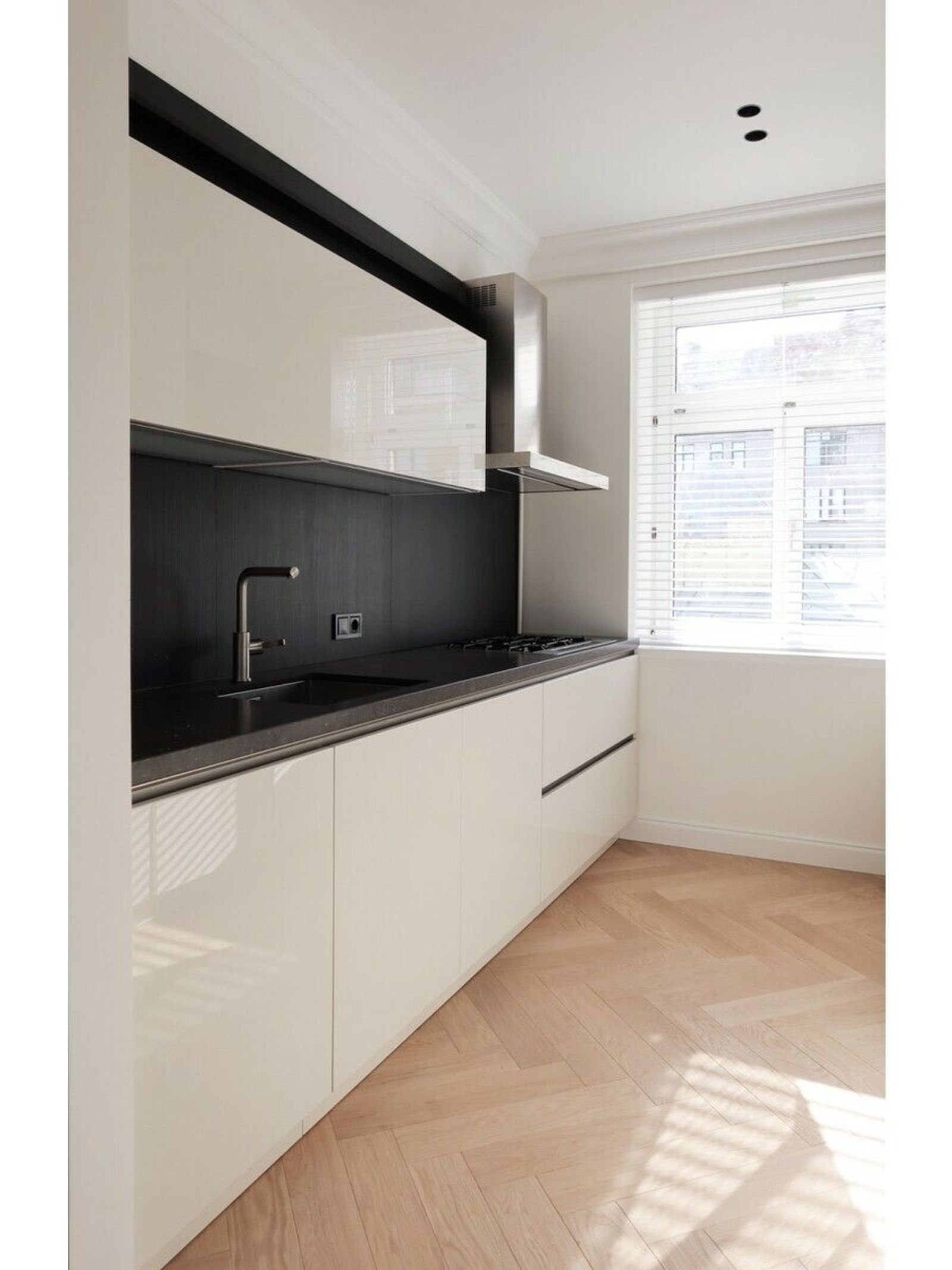 Modern kitchen with sleek white cabinets and herringbone wood floor, Pyrohova 2, Kyiv — Vestor.Estate