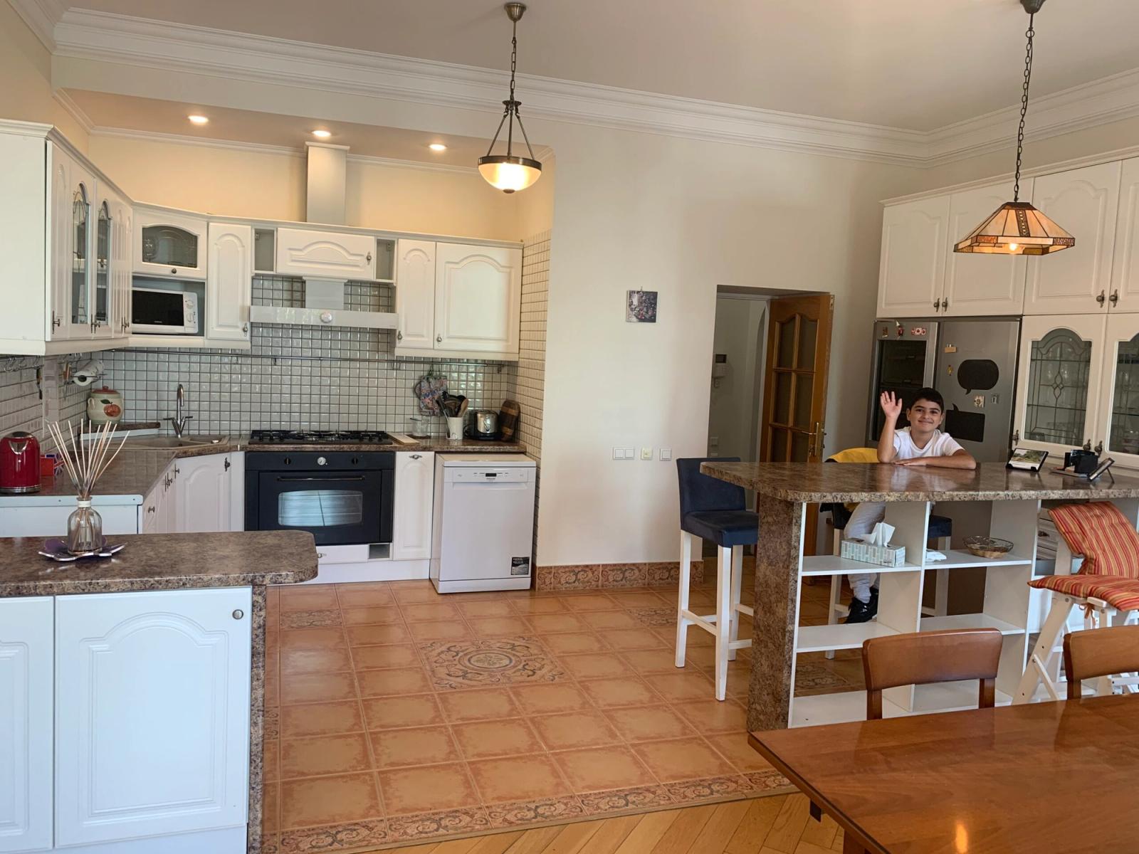 Spacious kitchen with island, white cabinets, and tile flooring, Ivana Franka 40, Kyiv — Vestor.Estate