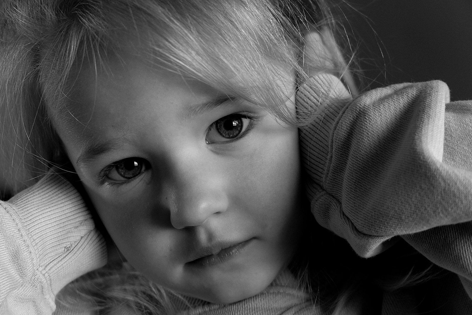 A black and white portrait of a young girl looking serious and worried