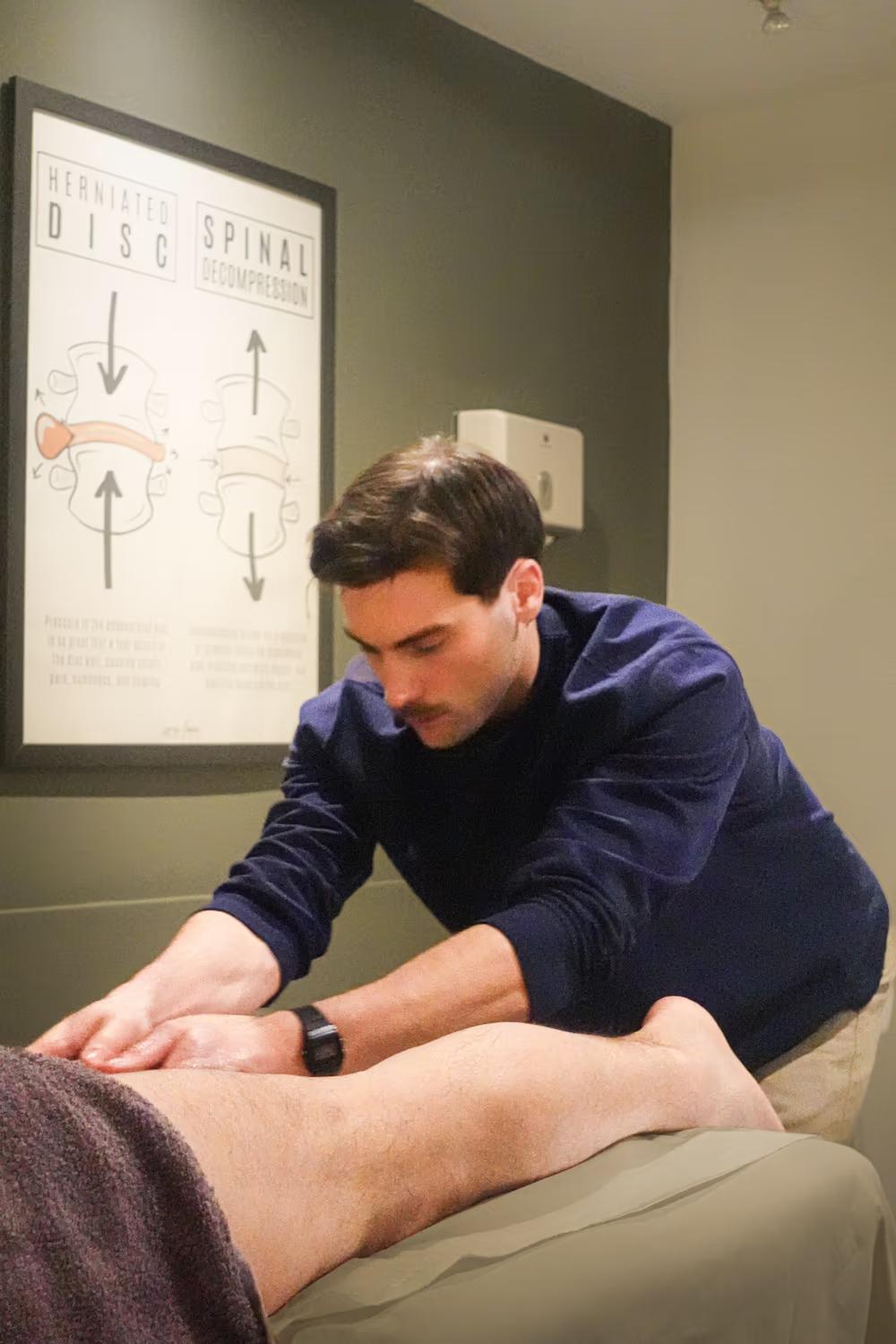 Sports massage therapist treating a patient’s lower leg at a Chiro London clinic