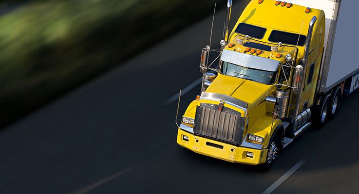Yellow semi truck driving on the freeway
