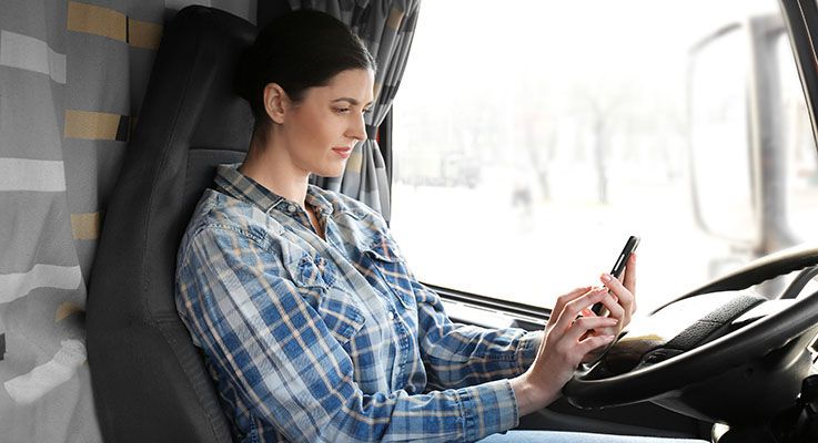 Truck driver using a trucker app on her smartphone