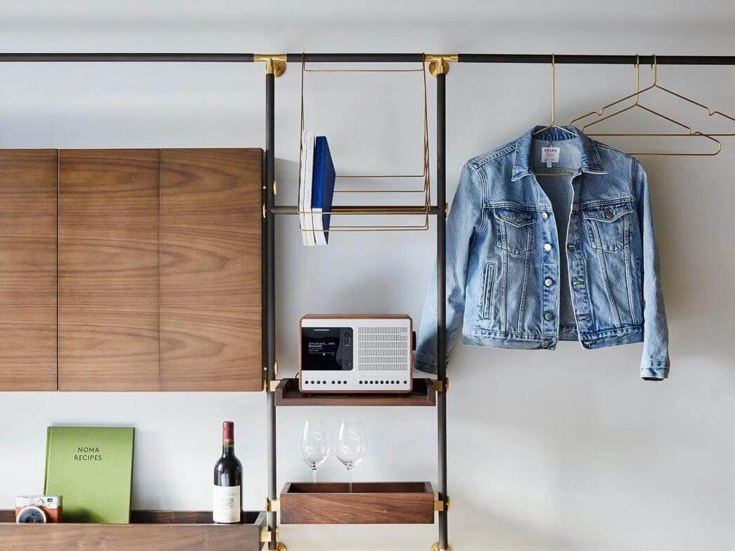 Room at MADE hotel, showing foldable desk, speaker, and hangers