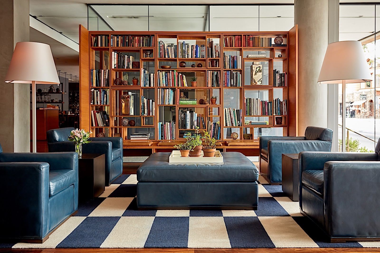 Hotel's lobby with leather armchairs and a big bookshelf