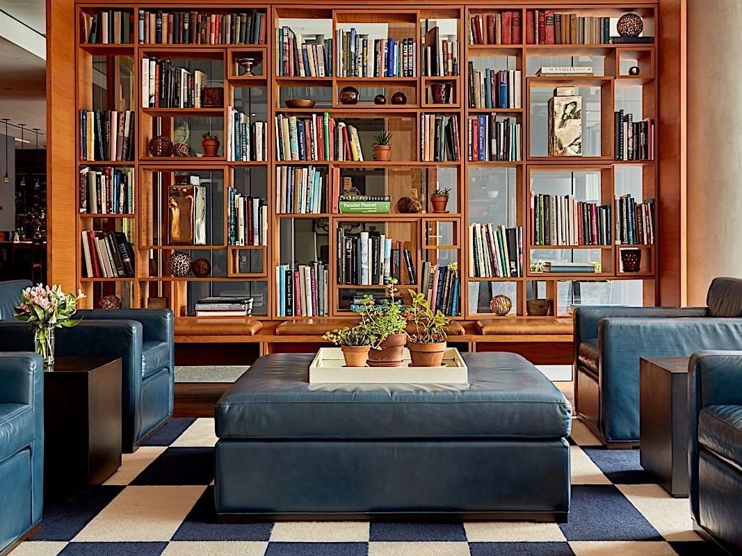 Hotel's lobby with leather armchairs and a big bookshelf