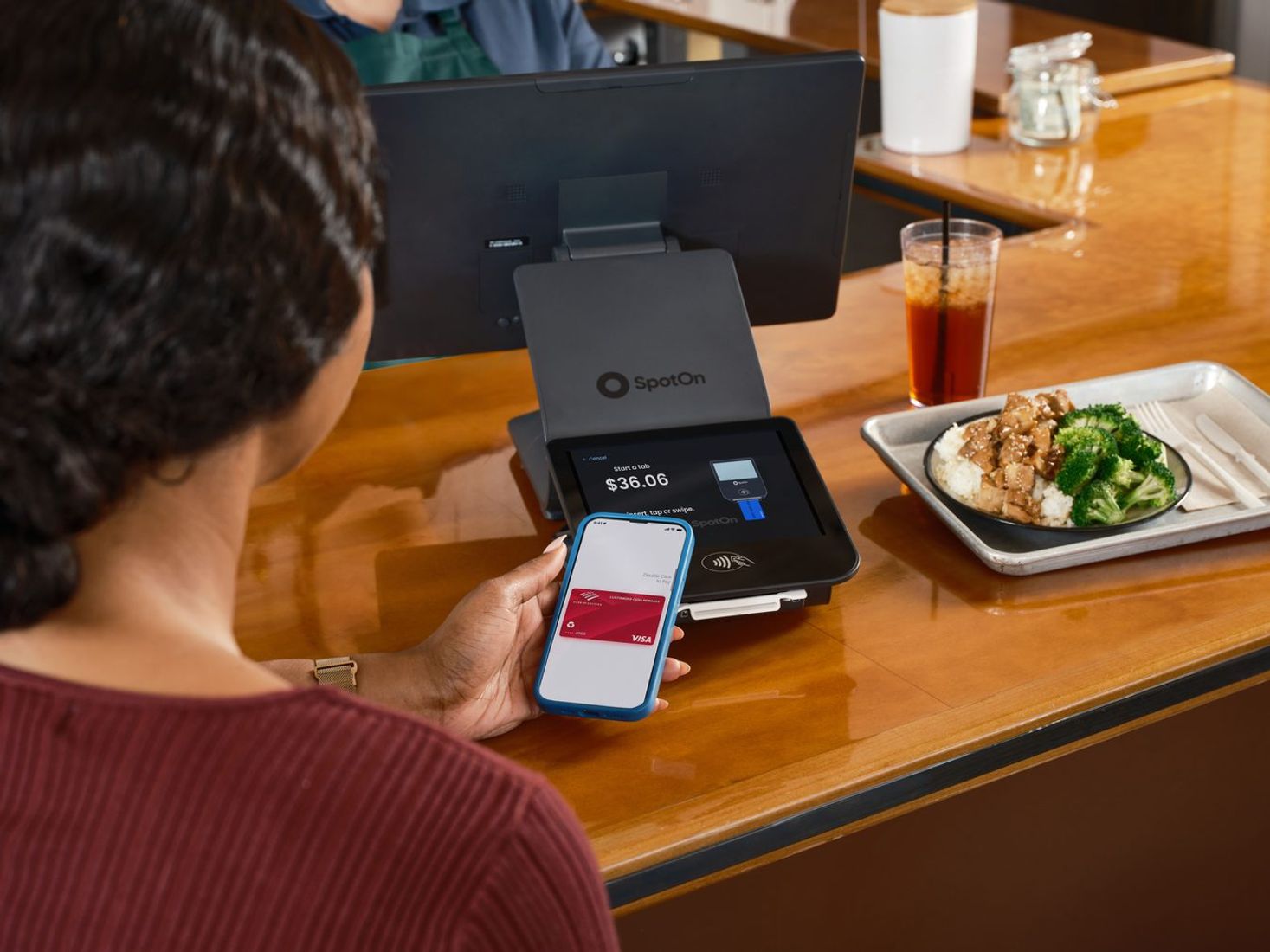 Customer using a smartphone for contactless payment at checkout.