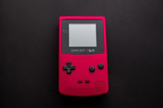 Close-up of a red Nintendo Game Boy Color on a dark backdrop