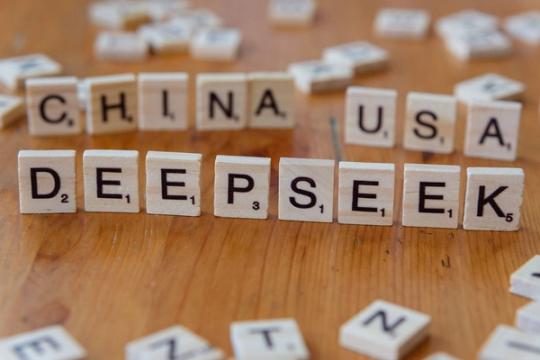 Wooden letter tiles spelling DEEPSEEK with CHINA and USA on a wooden table