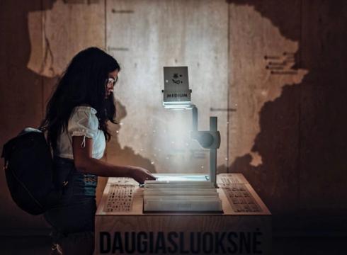 Moteris pristatymo aplinkoje su projektoriumi, simbolizuojanti saugumo ataskaitą.