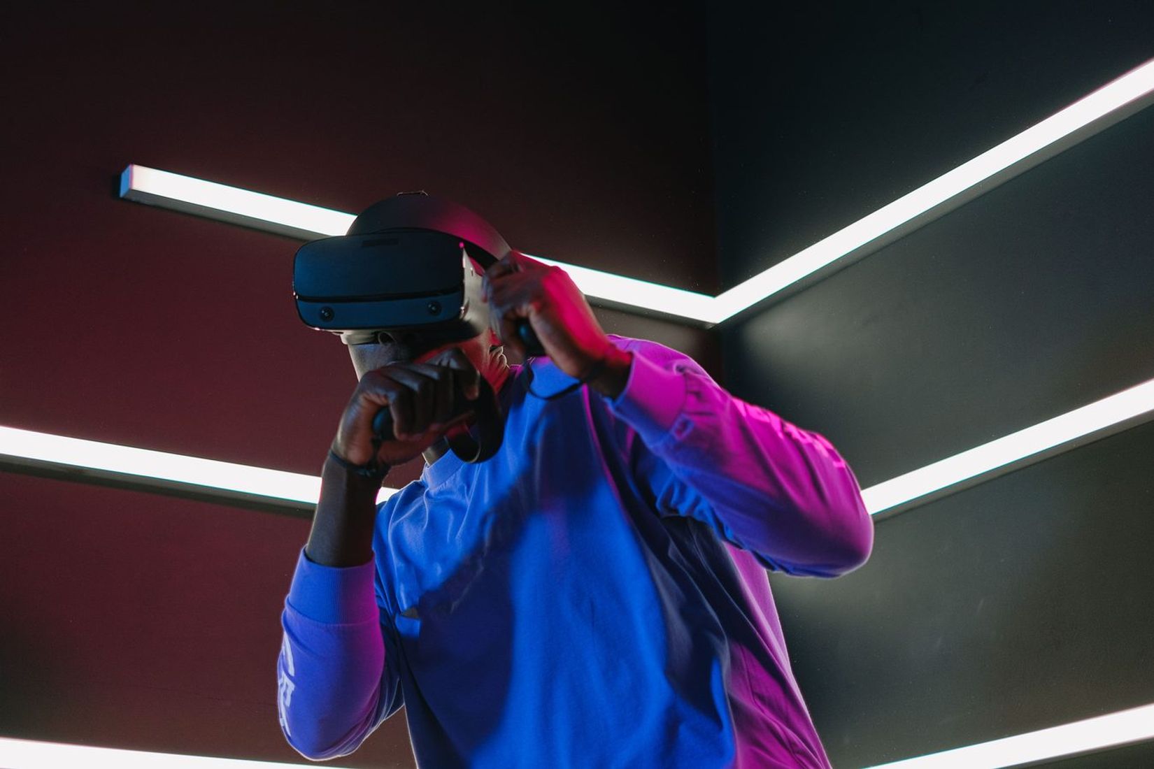 Žmogus su VR šalmu futuristinėje aplinkoje