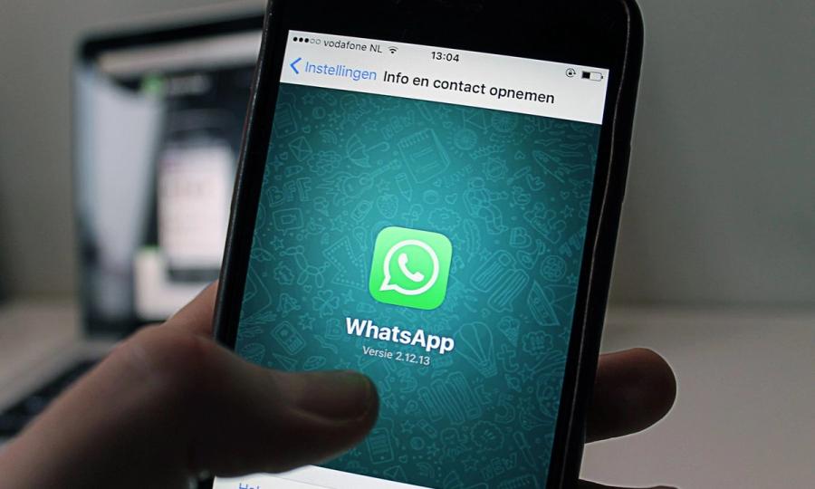 A smartphone displaying the WhatsApp application screen held by a person.