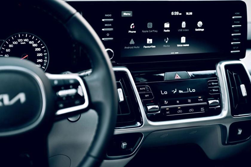 Modernus automobilio salonas su centriniu ekranu ir telefono integracija