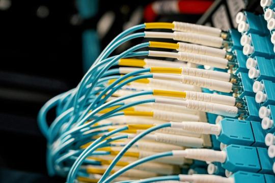 Fiber optical switch with connected cables in modern server room