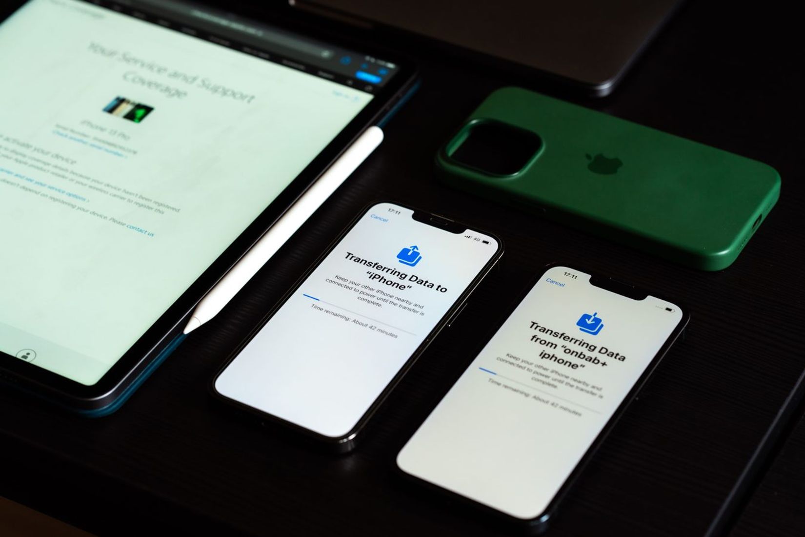 Iš viršaus matomi iPhone ir planšetė ant stalo.