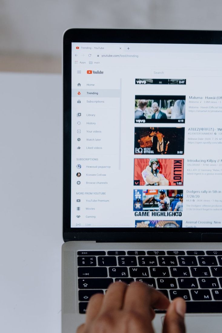 Žmogus naršo YouTube nešiojamajame kompiuteryje.