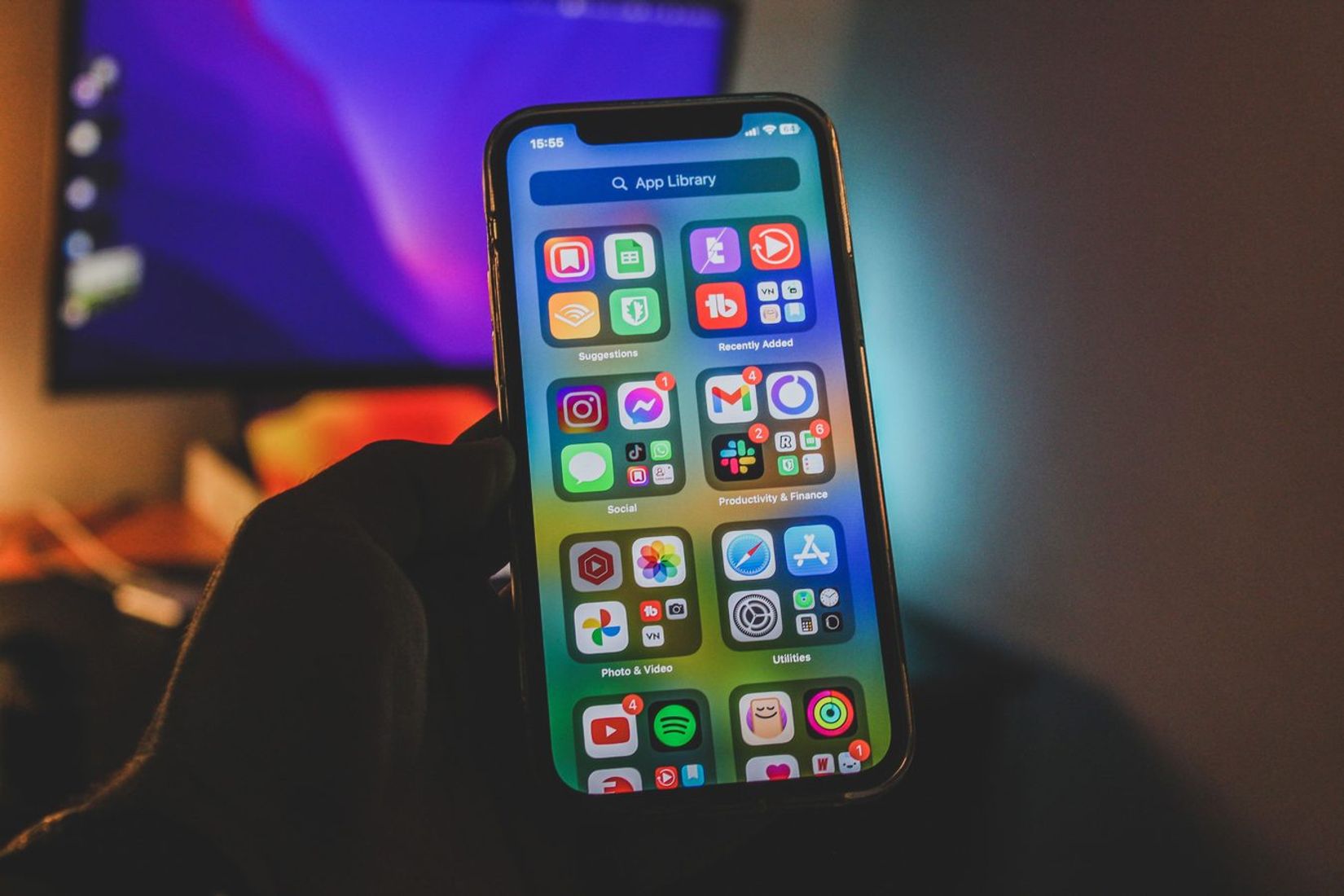 Rankoje laikomas išmanusis telefonas su spalvinga programėlių sąsaja