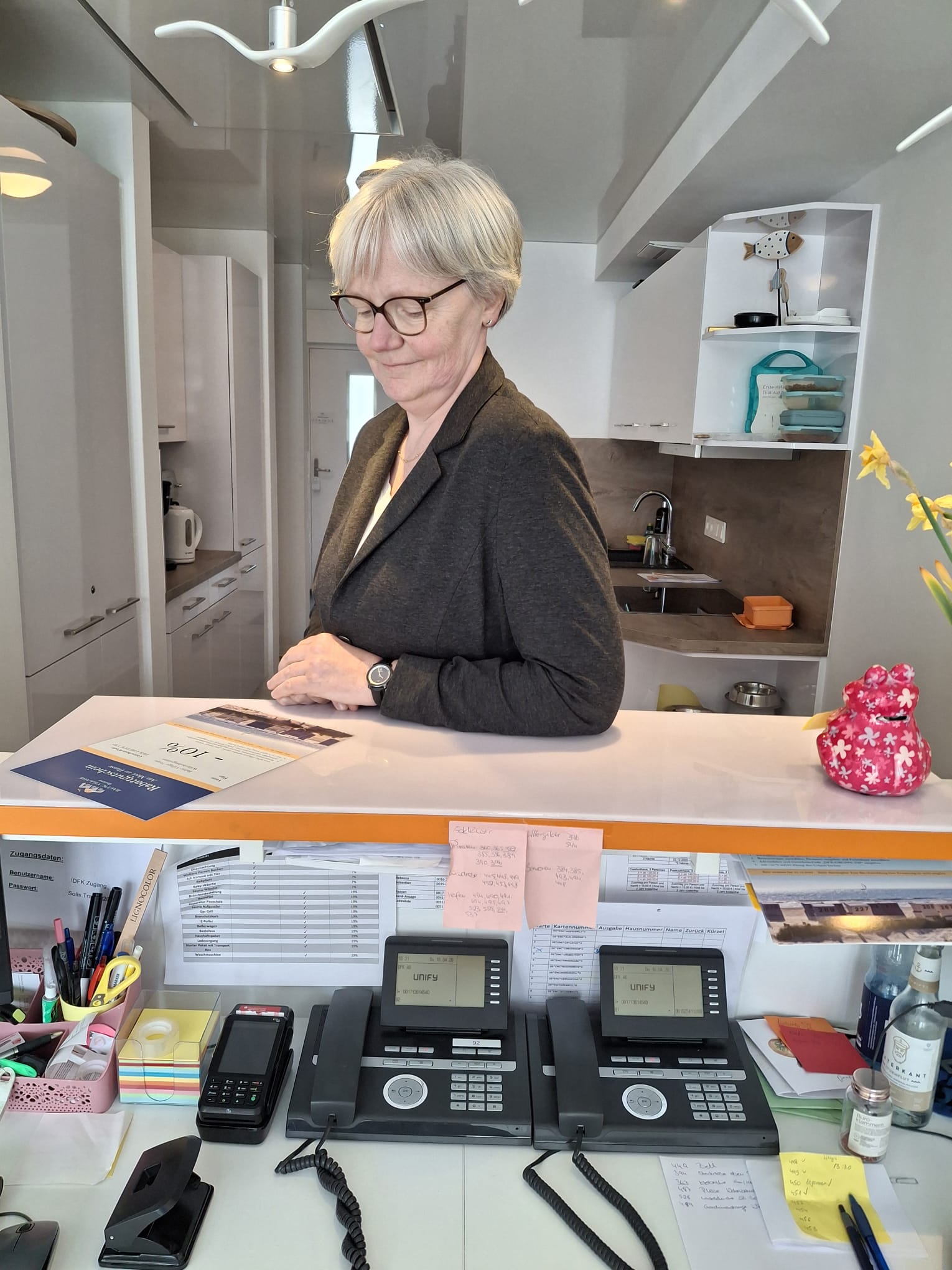 Ein Mann und eine Frau in Businesskleidung sitzen in einer Hotellounge bei einem Meeting; Tisch mit Kaffees, moderne Einrichtung.