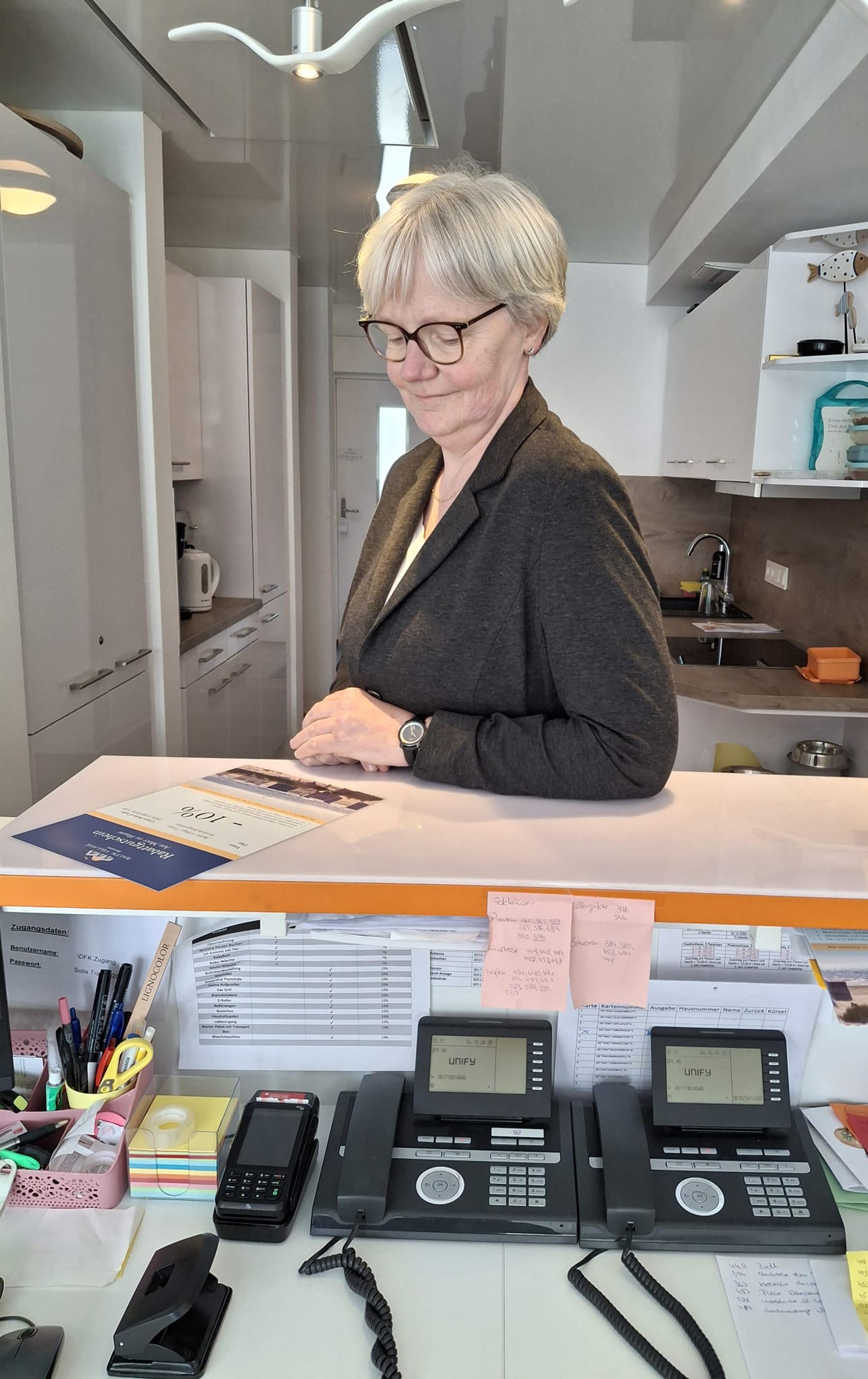 Ein Mann und eine Frau in Businesskleidung sitzen in einer Hotellounge bei einem Meeting; Tisch mit Kaffees, moderne Einrichtung.